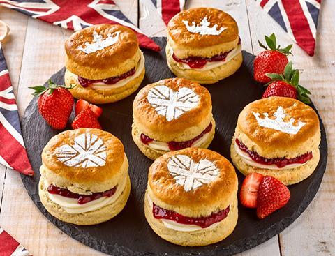 Scones with cream and jam in the middle and icing sugar crowns on top