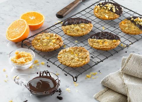 Orange cookies on a cooling rack dipped in chocolate