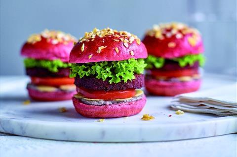 Three vegetarian sliders in bright pink buns with lettuce and tomato inside