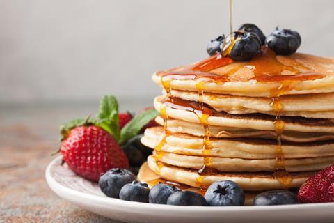 A pancake stack with syrup and blueberries on top