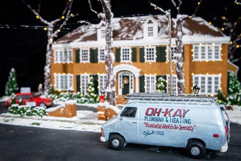 Home Alone's Oh-Kay plumbing van outside a gingerbread house