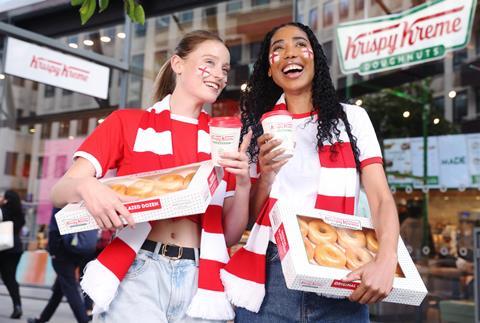 Two women celebrating the FIFA Women's World Cup with Krispy Kreme doughnuts