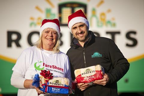 Ruth Downes from Fareshare & Will Harrop from Roberts Bakery in Christmas hats, holding loaves of bread