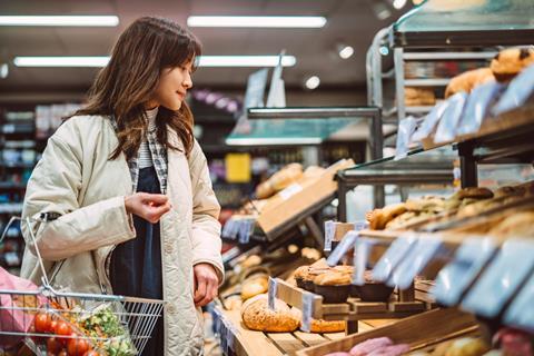 Woman choosing fresh bakery products in supermarket