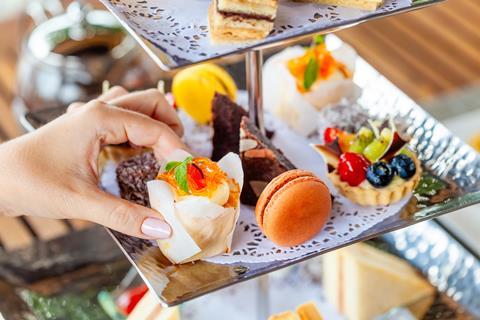 Fruit tart, macaron, and cakes on an afternoon tea stand