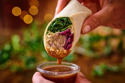 A steak wrap being dipped in lashings of gravy