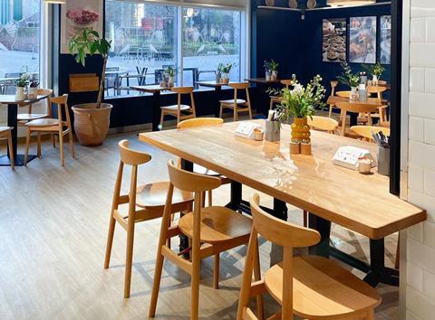 Wooden tables and chairs at Two Magpies Norwich site