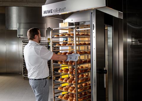 Man rolling burger buns into MIWE roll-in oven