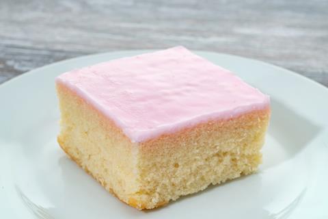 A white sponge cake with pink icing