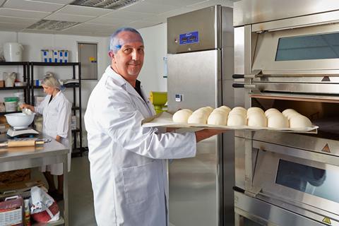 An I.T.S staff member puts bread rolls in an oven at the test bakery in Newbury, Berkshire  2100x1400
