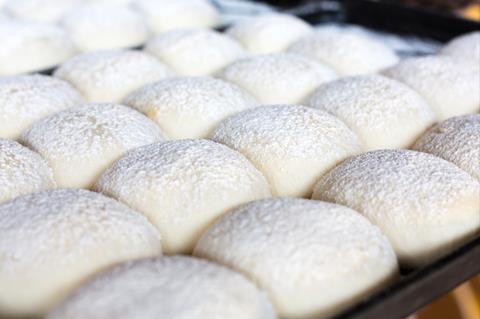 A close-up of floured baps before baking