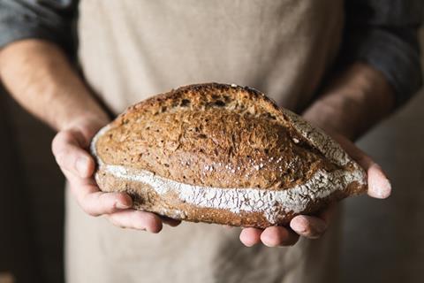 Baker holding artisanal loaf