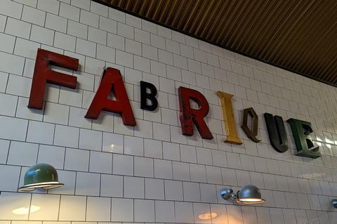Fabrique bakery sign on a white tiled wall