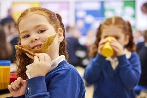 Ginger haired child eating toast at a Greggs breakfast club