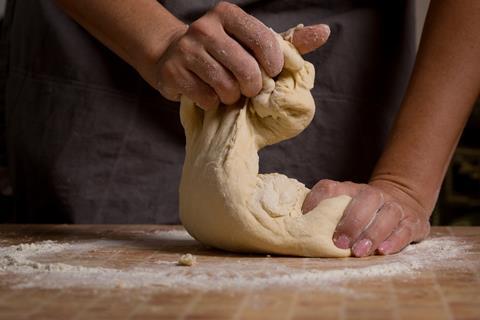 A female baker's hands kneading dough