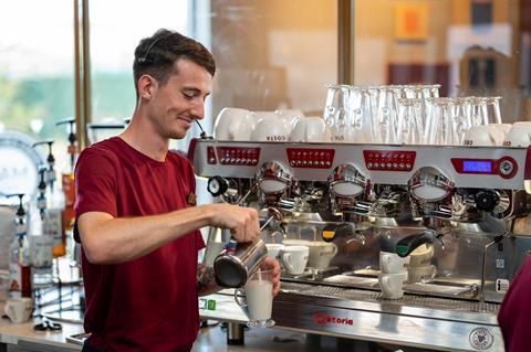A Costa Coffee employee making coffee