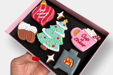 Beautifully iced Christmas cookies in the shape of a Christmas tree, bauble, fireplace, hot chocolate, and slippers