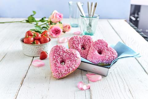 Heart shaped doughnuts with pink icing and sprinkles