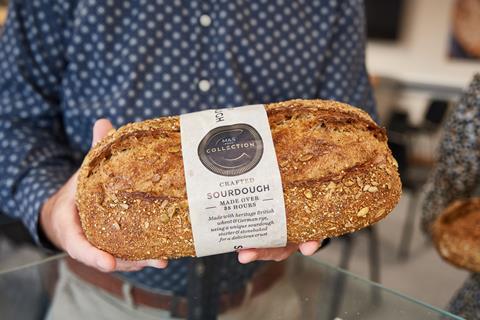 A seeded sourdough loaf in a man's hands