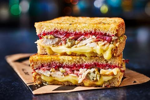 A stacked turkey toastie with layers of stuffing, cranberry sauce and melted cheese