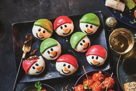 Bao buns made to look like snowmen faces with green and red hats on