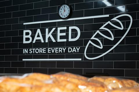 A tiled wall of an Asda bakery with the stencilled slogan 