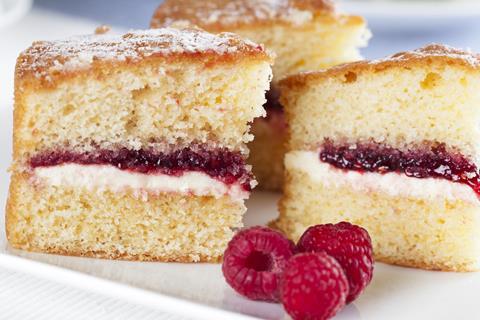 A close up of a Victoria sponge cake with jam and cream in the middle