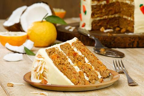 A slice of a tropical paradise cake made with carrot cake with yuzu frosting on top