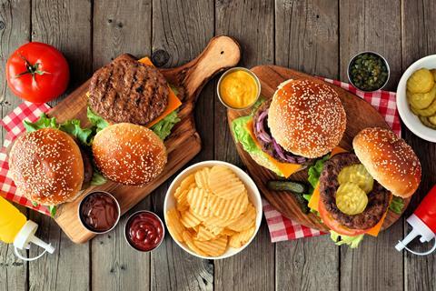 Burgers on wooden boards with crisps and sauces