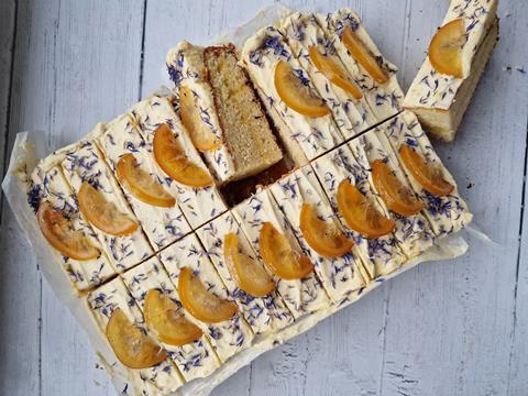 An orange, cardamom and bay tray cake with corn flowers and candied orange on top