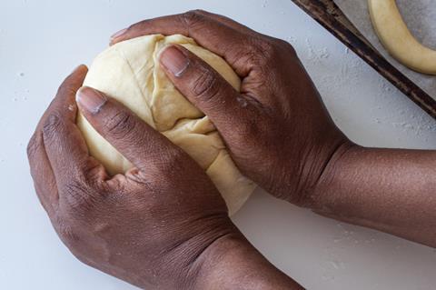 Black hands kneading pastry