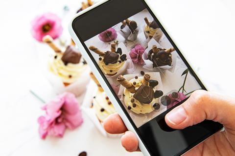 Person taking photo of cupcakes on phone