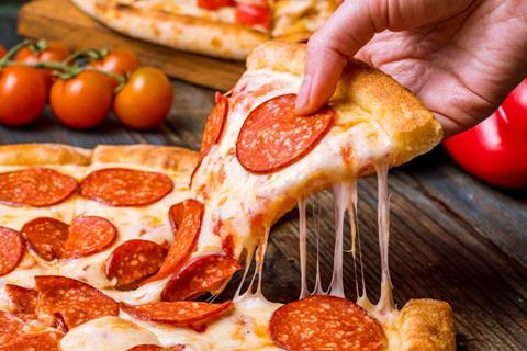 A hand taking a slice of pepperoni pizza