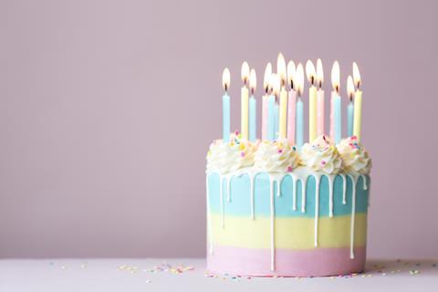 A pastel birthday cake with white chocolate drip frosting