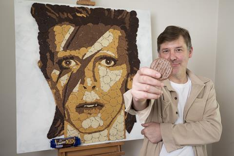Pladis - Mosaic artist Ed Chapman  stands in front of his David Bowie artwork created out of McVitie's Chocolate Digestives - 2100x1400