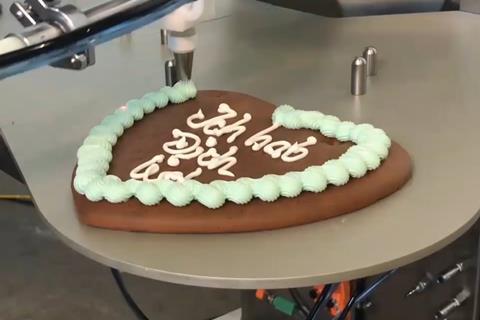 Unifiller's Bakerbot icing a gingerbread biscuit