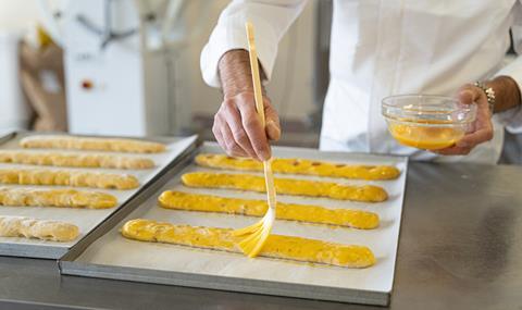 A pastry chef adding glaze to dough