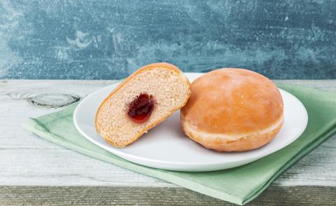 A jam doughnut cut in half on a blue background