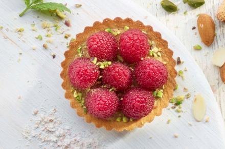 A crimped pastry tart with raspberries on top