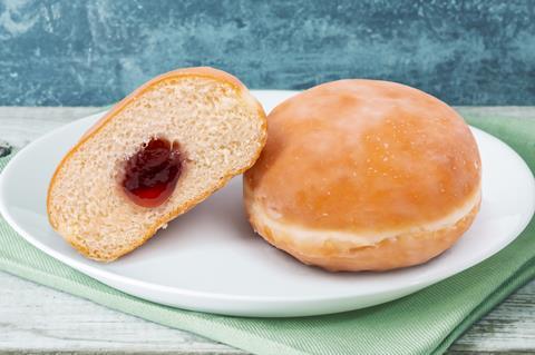 A jam doughnut cut in half on a blue background