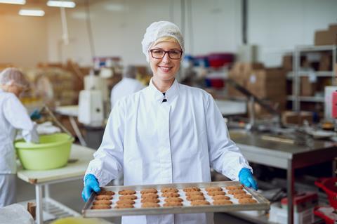 Baker in PPE with cookies