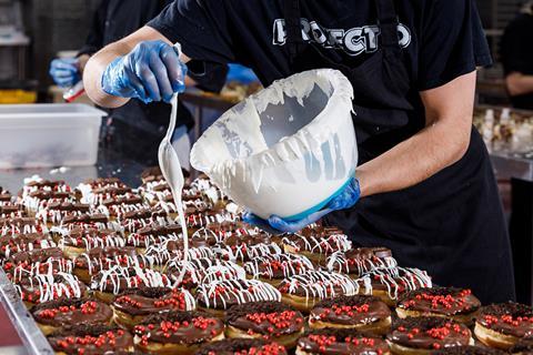 A worker decorates doughnuts at Project D's factory in Spondon, Derby  2100x1400