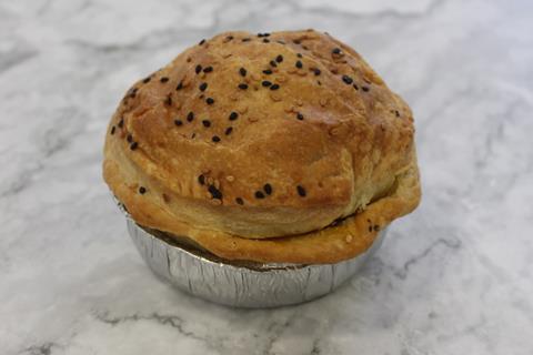 A pie on a marble background with sesame seeds on top
