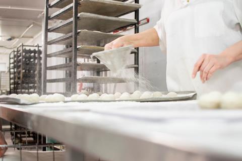 The Bread Factory person dusting rolls