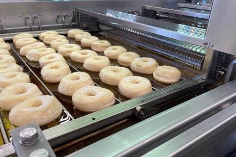 Doughnuts being fried on an industrial line