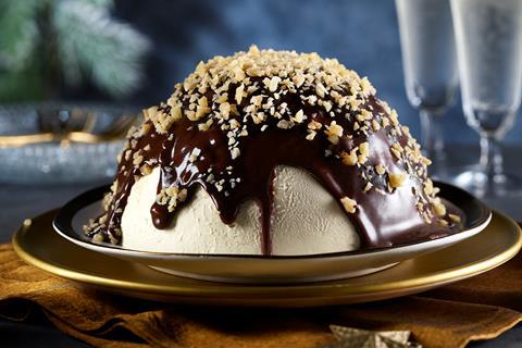 A salted caramel semi freddo with chocolate sauce cascading down it and a sprinkling of nuts on top