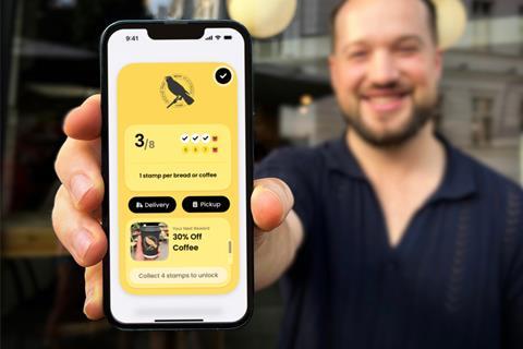 Embargo - Man displays phone with Blackbird Bakery app - 2100x1400