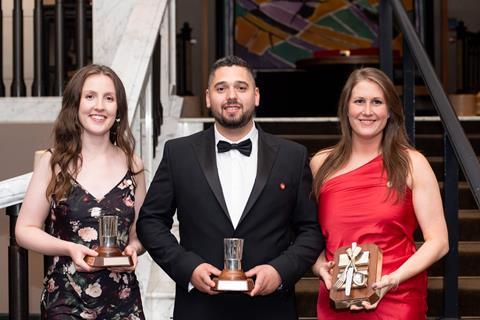 Two women and a man with trophies