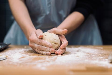 A woman's hands shaping a ball of dough