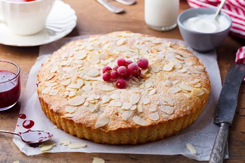 A bakewell tart with red berries and almond slices on top